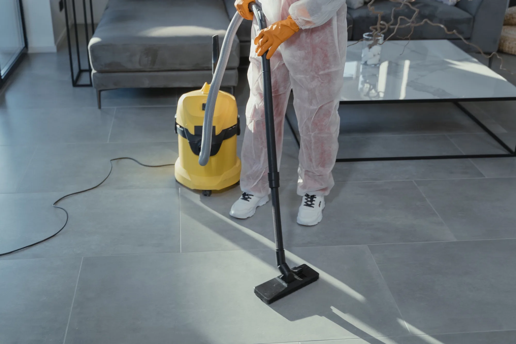 Profissional da Atributo Cristalizado a fazer limpeza industrial com aspirador